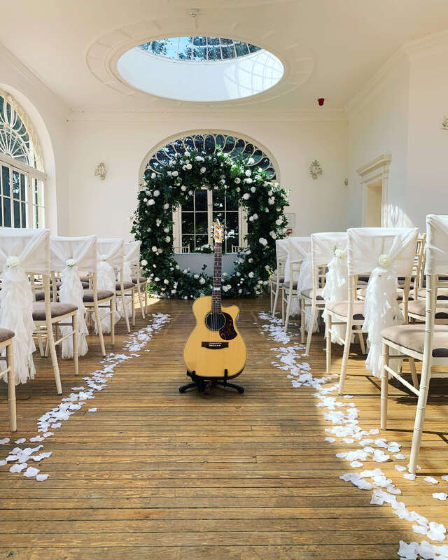 Acoustic guitar in a ceremony room at Barton Hall Orangery with flowers and decorations