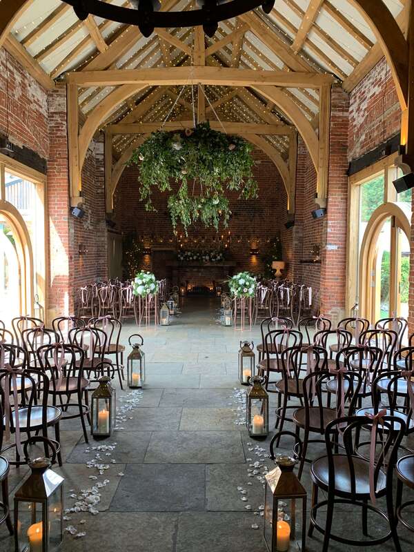 Acoustic guitar during the ceremony at hazel gap barn with brown wooden chairs and flowers